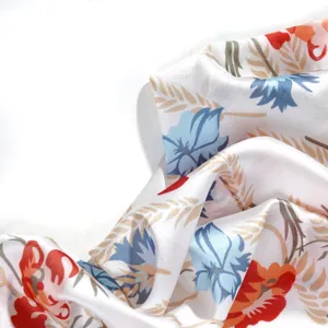 Close up view of smooth white fabric featuring colorful floral print and soft draping details.