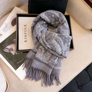 Detailed view of a thick grey paisley jacquard scarf, soft winter accessory for women.