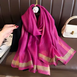 Detail shot of elegant magenta shimmering long silk scarf with stylish border stripes for women.