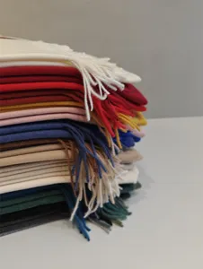 Gestapelte einfarbige Kunstkaschmir-Schals mit feinen Fransen fuer stilvolle Wintermode.