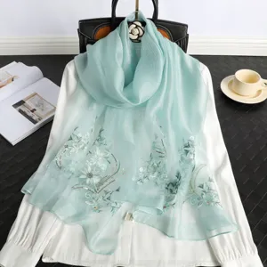 Elegant light blue silk embroidered scarf with delicate floral design for women, summer wrap.