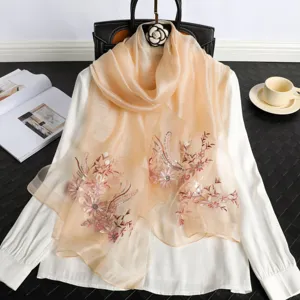 Detail view of a luxurious sheer silk scarf featuring exquisite floral embroidery and elegant drape.