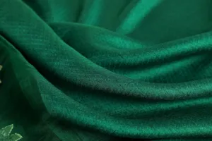 Detailed close-up view of dark green silk wool blend scarf fabric showing soft luxurious texture.