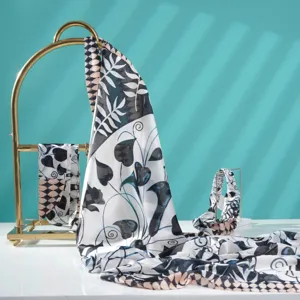 Close-up detail of lightweight printed silk scarf featuring botanical leaf and geometric patterns.