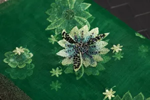 Green silk wool embroidered scarf detail showing intricate floral beadwork texture close up.