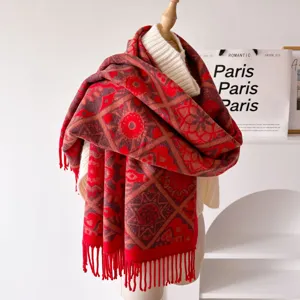 Detailed shot of thick red patterned winter scarf with retro geometric print and tassel hem.