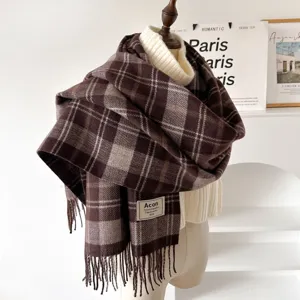 Detailed shot of brown plaid tassel winter scarf draped on mannequin, cozy texture.