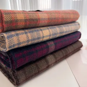 Detailed close-up of folded autumn and winter plaid scarves showing soft textured fabric.