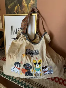 Borsa a tracolla casual in tela con tracolla larga intrecciata e ricamo di cuccioli carini.