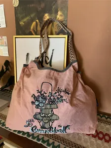 Vista dettagliata della borsa a spalla capiente con ricamo floreale e tracolle tessute.