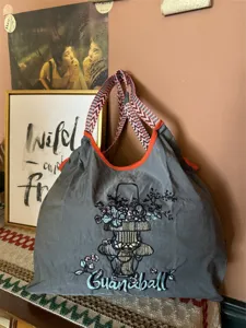 Borsa a tracolla ampia ed elegante con larga cinghia tessuta e bellissimo ricamo floreale.