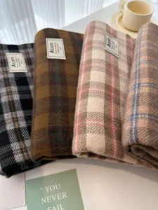 Detailed shot of plaid winter scarves, soft textured fabric, cozy neck warmers for cold weather.