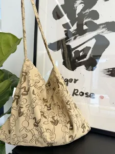 Detail view of the beige corduroy shoulder bag featuring cute rabbit prints and soft texture.