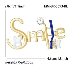 Gold tone dental theme brooch detail showing smile lettering, toothbrush, and sparkling crystal.