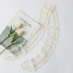 Vue détaillée du ruban de dentelle blanche, design en filet floral délicat pour le style de sac.
