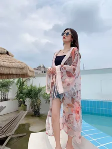 Outdoor detail view of a floral print long sleeve summer beach sunscreen cardigan cover-up.