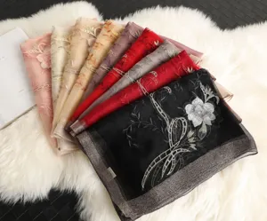 Detailed view of luxurious embroidered silk-wool blend scarves with exquisite floral patterns.