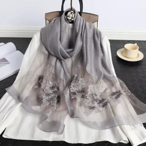 Elegante bufanda de seda gris con intrincados bordados florales y cuentas brillantes.