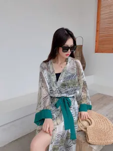 Tropical leaf print kimono beach cover-up with green waist tie and long sleeves for summer.