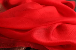 Close-up detail of red silk wool embroidered scarf, soft texture and elegant winter accessory.