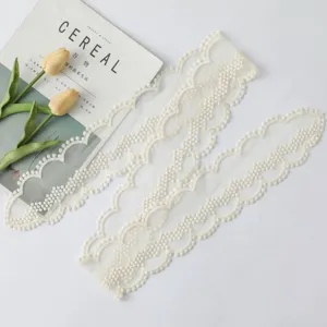 Ruban de dentelle blanc cassé élégant, idéal pour déco de sac, coiffure ou accessoires.