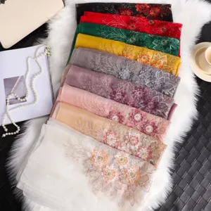 Elegante bufanda de seda bordada con cuentas, diseño floral y colores vibrantes.