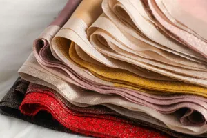 Detailed closeup of luxurious silk scarves showing rich texture and vibrant colors.