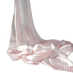 Sciarpa di seta rosa e bianco con classico motivo paesaggistico drappeggiato elegantemente sul fondo.