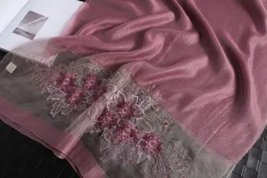 Vista detallada de elegante bufanda de mezcla de seda y lana bordada con flores delicadas y brillo.