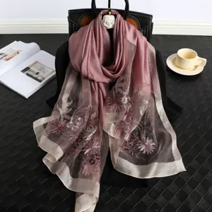 Detailed view of the elegant pink silk embroidered scarf with floral pattern and fine border.