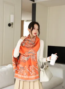 Detailansicht des eleganten orangefarbenen Kaschmir-Schals mit Paisleymuster und Fransen.
