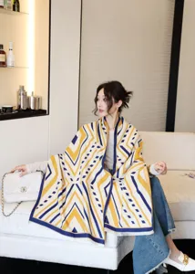 Comodo scialle con motivo geometrico giallo e blu, vista dettagliata di stile di vita indoor.