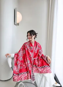 Vista dettagliata di una sciarpa scialle rossa spessa da donna con motivo cachemire elegante.