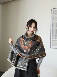 Elegant ethnic print winter shawl in dark grey with orange floral motifs and cozy tassels.