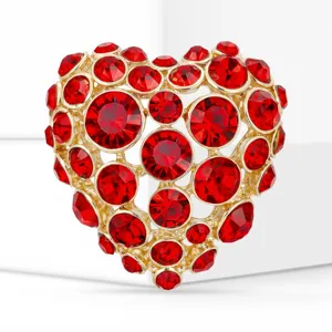 Gros plan détaillé d'une broche cœur en cristal rouge étincelant en alliage doré, détail de bijoux.