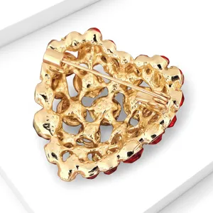 Vue arrière détaillée d'une broche cœur dorée texturée élégante avec des cristaux rouges.