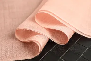 Lightweight pink sheer fabric shawl or scarf detail, soft and elegant drape for women.