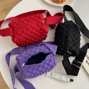Detail shot of stylish knit crossbody bags in vibrant colors with unique crinkle texture.