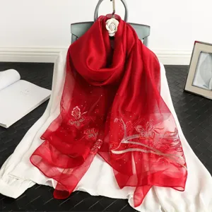 Red silk scarf detail, butterfly embroidery, rhinestone decor, elegant neck accessory close-up.