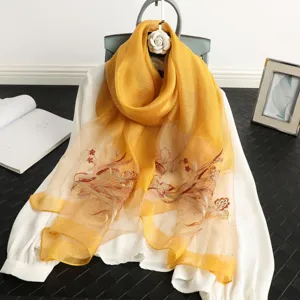 Detail view of yellow silk scarf with exquisite rhinestone butterfly embroidery and soft sheen.