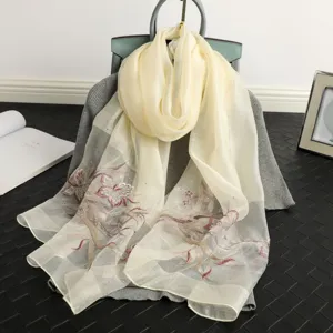 Exquisite mulberry silk scarf featuring delicate floral embroidery and sparkling rhinestones.