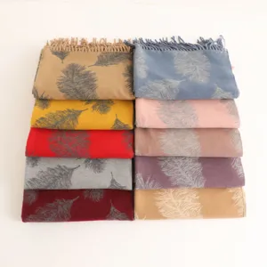 Detailed view showing multiple colorful feather patterned cashmere scarves with tassels.