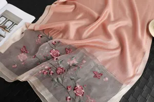 Detailed view of luxury pink silk wool scarf featuring exquisite floral embroidery and beadwork.