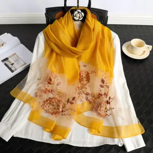 Exquisite yellow silk scarf with delicate floral embroidery, elegant detail shot for spring wear.