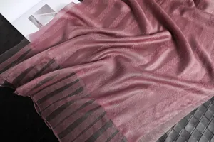 Detailaufnahme eines eleganten malvenfarbenen Seiden-Wollschals mit feinem Gittermuster und weich.