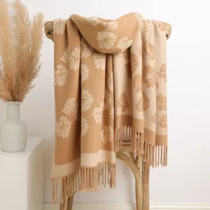 Detailed view of thick warm double-sided floral jacquard scarf with fringe in beige
