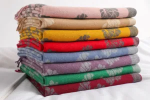 Close-up detail of folded warm core-spun yarn autumn and winter scarves in multiple colors.