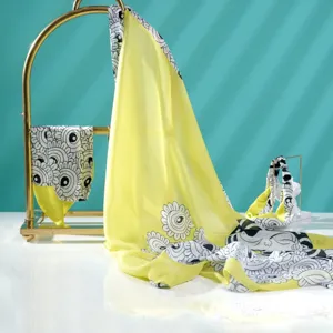 Detailed view of the elegant lemon yellow silk scarf featuring unique black and white artistic prints.
