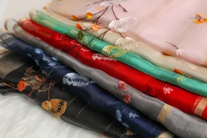 Elegant silk embroidered scarf featuring delicate floral patterns, soft sheer fabric, versatile.