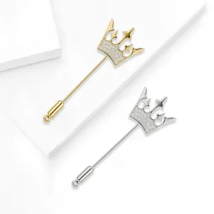 Dettaglio squisito di spilla a corona con strass scintillanti e finitura in metallo lucido.